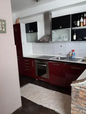 a kitchen with red cabinets and a sink at Vila Maljevik in Sutomore