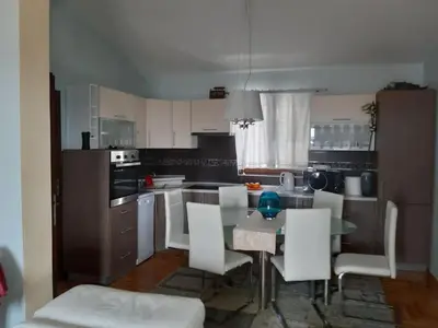 a kitchen with a table and some white chairs at Vila Maljevik in Sutomore