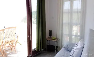 a living room with a couch and a large window at Vila Maljevik in Sutomore