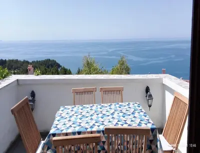 a table and chairs on a balcony with the ocean at Vila Maljevik in Sutomore