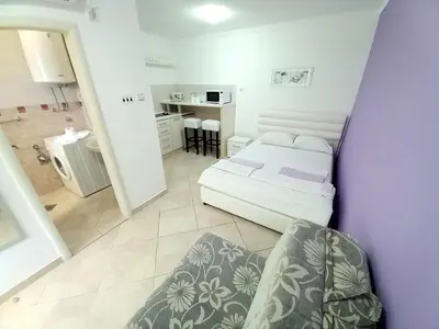a small bedroom with a bed and a kitchen at Kotor Sunrise Apartments in Kotor