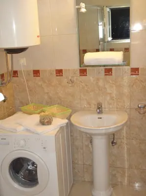 a bathroom with a washing machine and a sink at Kotor Sunrise Apartments in Kotor