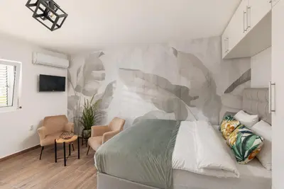 a bedroom with a bed and a wall mural at Kotor Sunrise Apartments in Kotor