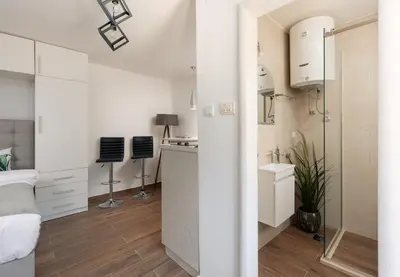 a bedroom with a bed and a bathroom with a sink at Kotor Sunrise Apartments in Kotor