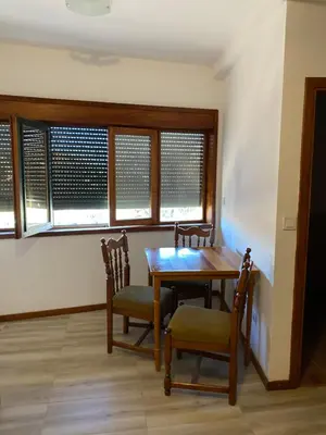 a dining room with a table and chairs and windows at Jednosoban stan Lucija in Bar