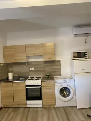 a kitchen with a stove and a washing machine at Jednosoban stan Lucija in Bar