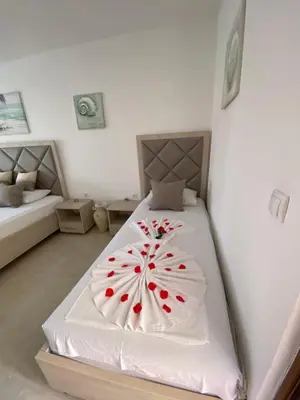a bedroom with a bed with a flower on it at Apartments Gusar in Ulcinj