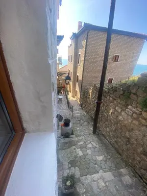 an outside view of a stone alley with a building at Apartments Gusar in Ulcinj