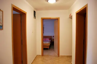 a hallway with two doors and a room with a bed at Omega Apartments in Ulcinj