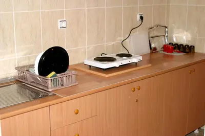 a kitchen counter with a stove and a drying rack at Omega Apartments in Ulcinj