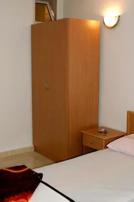 a bedroom with a bed and a wooden cabinet at Omega Apartments in Ulcinj