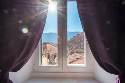 a window in a room with a view of a city at Old Town Experience Apartment in Kotor