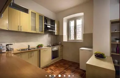 a kitchen with yellow cabinets and a counter top at Old Town Experience Apartment in Kotor