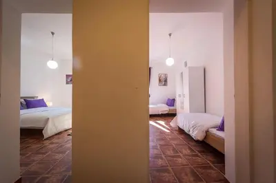 a room with two beds and a hallway with two beds at Old Town Experience Apartment in Kotor