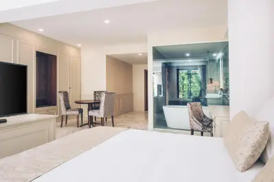 a bedroom with a bed and a bathroom with a tub at Iberostar Waves Slavija in Budva