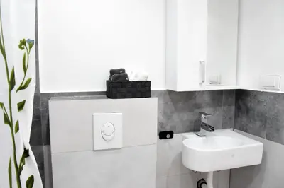 a white bathroom with a sink and a toilet at Lana & Ena Apartments in Kotor