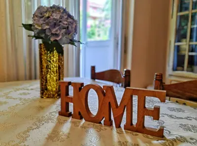 a wooden sign on a table with a vase of flowers at Apartment Adriatic - Budva in Budva