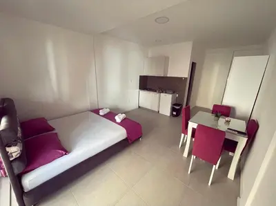 a bedroom with a bed and a table and chairs at Apartmani Agi in Budva