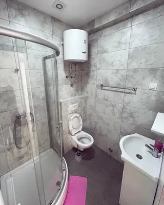 a bathroom with a shower and a toilet and a sink at Apartmani Agi in Budva