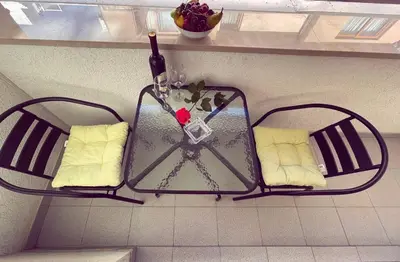 a glass table with two chairs and a bottle of wine at Apartmani Agi in Budva