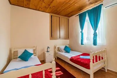 two beds in a room with a window at Guest House Luna in Virpazar