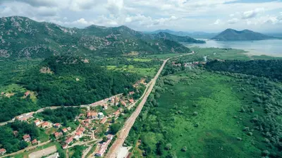 an aerial view of a town on a hill next to a river at Guest House Luna in Virpazar