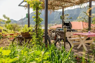 a bike parked next to a table and a picnic table at Guest House Luna in Virpazar