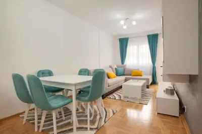 a living room with a table and chairs and a couch at Apartman 104 in Budva