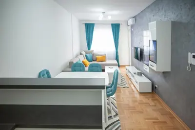 a small living room with a couch and a tv at Apartman 104 in Budva