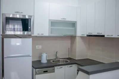 a kitchen with a sink and a white refrigerator at Apartman 104 in Budva
