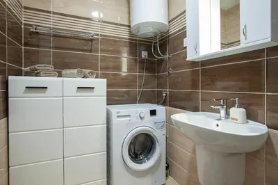 a bathroom with a washing machine and a sink at Apartman 104 in Budva