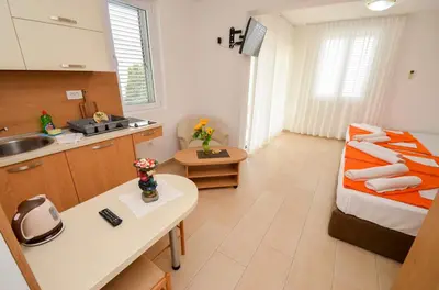 a small kitchen with a bed and a sink at Apartments Ivanović in Budva