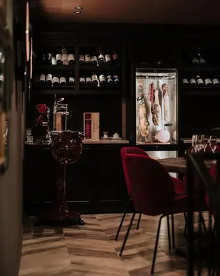 a dining room with a table and red chairs at Boscovich Boutique Hotel in Podgorica