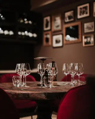 a table with wine glasses on it in a restaurant at Boscovich Boutique Hotel in Podgorica