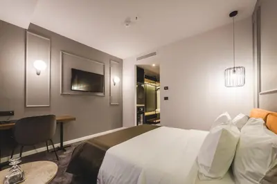 a hotel room with a bed and a desk and a desk at Boscovich Boutique Hotel in Podgorica