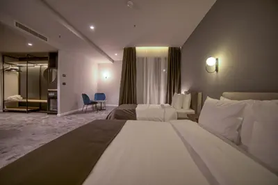 a hotel room with two beds and a bathroom at Boscovich Boutique Hotel in Podgorica