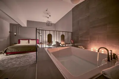 a large bathroom with a tub and a bed at Boscovich Boutique Hotel in Podgorica