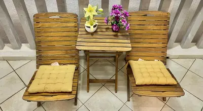 a table and two chairs with a table and flowers at Apartment Studio Premier in Rafailovici