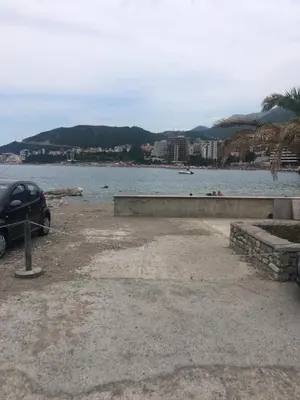 a car parked next to a body of water at Apartment Studio Premier in Rafailovici