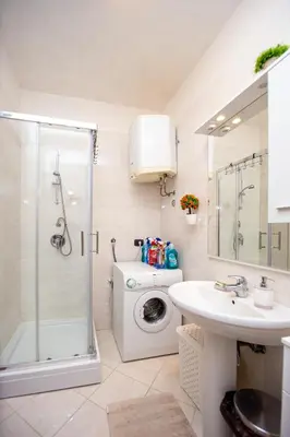 a bathroom with a washing machine and a sink at Apartment Studio Premier in Rafailovici