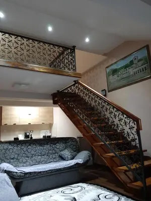 a staircase in a living room with a couch at APARTMANI MIA VUKSANOVIC in Cetinje