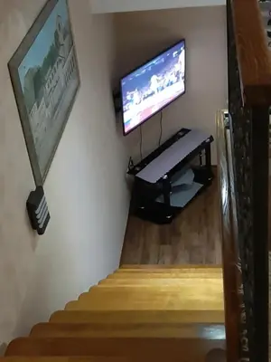a room with a tv and a staircase with a television on the wall at APARTMANI MIA VUKSANOVIC in Cetinje