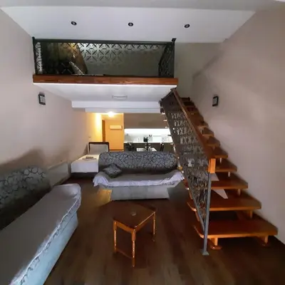 a room with a staircase with a couch and a bed at APARTMANI MIA VUKSANOVIC in Cetinje
