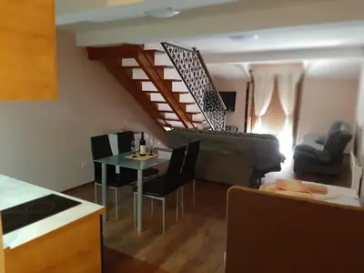 a kitchen and living room with a table and chairs at APARTMANI MIA VUKSANOVIC in Cetinje