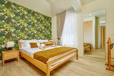 a bedroom with a bed with a green wall at MAISON W in Kotor