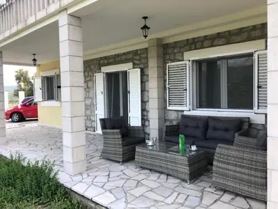 a patio with wicker furniture on a house at Vila Jovanka in Tivat