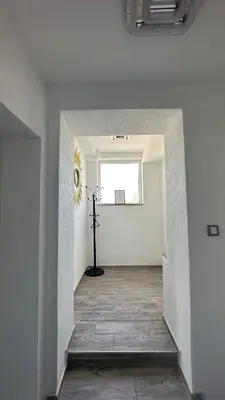 an empty hallway with a clock on the wall at Vila Jovanka in Tivat
