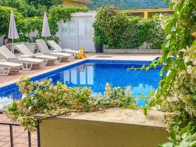 a swimming pool with lawn chairs and umbrellas at Luxurious Apartments Aria in Budva