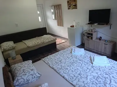 a living room with a couch and a flat screen tv at Studio and winery Kalimut in Virpazar