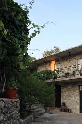 a stone house with a patio and a balcony at Studio and winery Kalimut in Virpazar